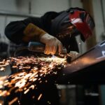 Worker grinding a piece of metal