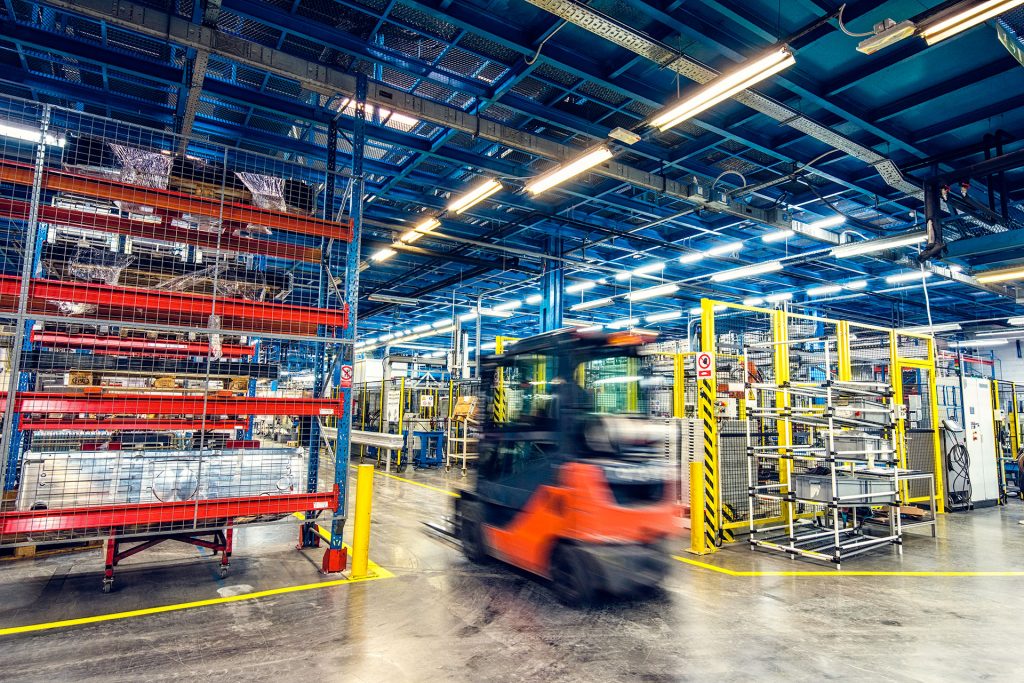 Automated forklift navigating a fulfillment center warehouse.